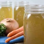 Quart sized canning jars filled with a yellow broth.