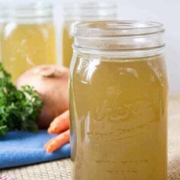 Quart sized canning jars filled with a yellow broth.