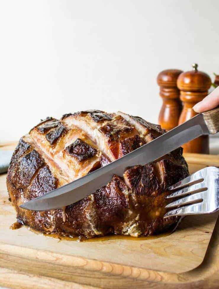 Baked Ham being sliced with a large knife.