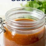 A glass jar filled with enchilada sauce.