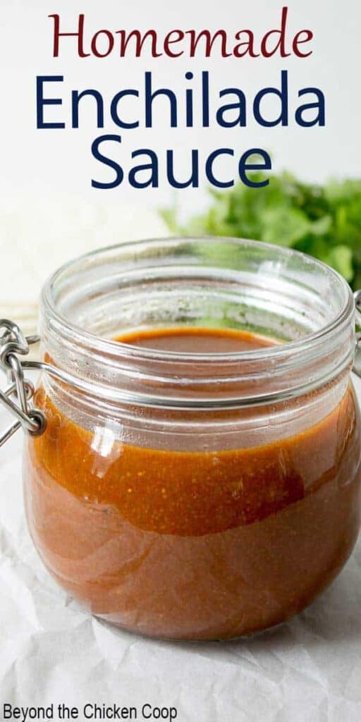 A glass jar filled with enchilada sauce.