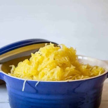 A blue dish filled with strands of spaghetti squash.