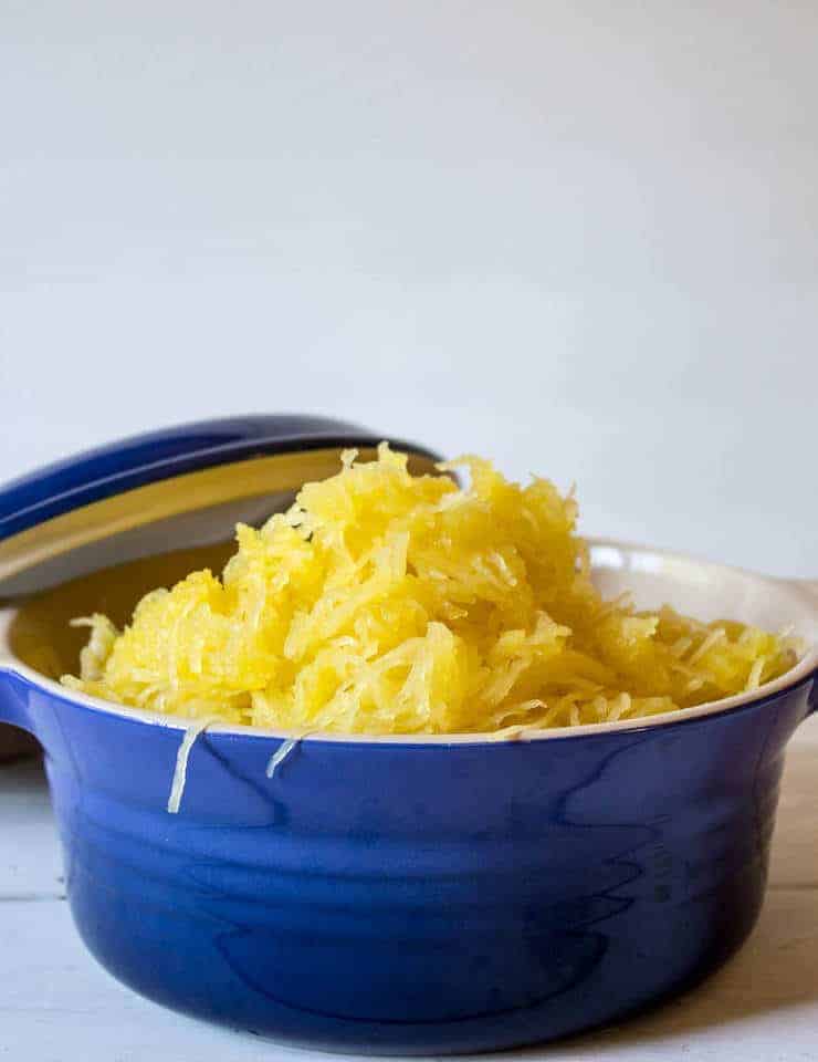 A blue dish filled with strands of spaghetti squash.