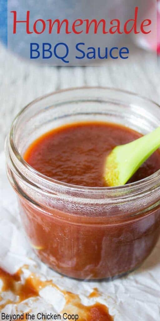 Barbecue Sauce in a glass jar with a green pastry brush.