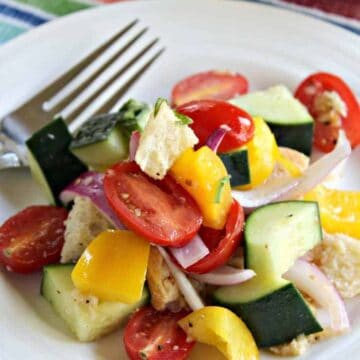 Panzanella Salad on a white plate with a fork.