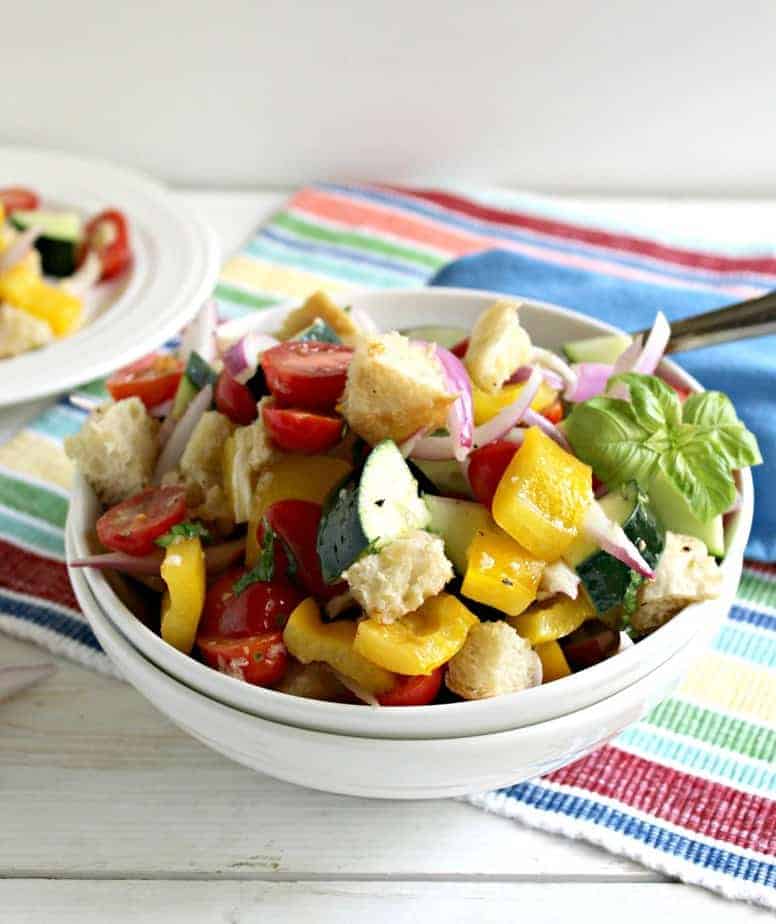 Fresh salad with veggies in a white bowl.