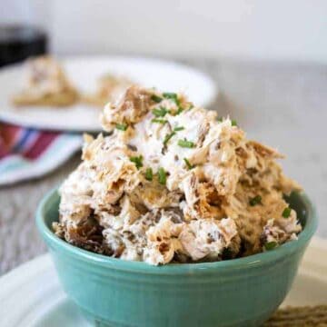 A bowl full of a dip with chunks of salmon.