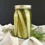 A glass canning jar filled with pickle spears.