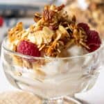 Yogurt topped with crunchy granola and fresh raspberries.