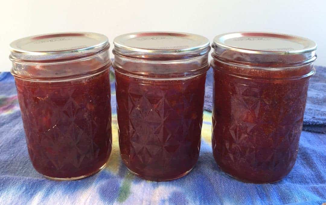 Three canning jars filled with jam.
