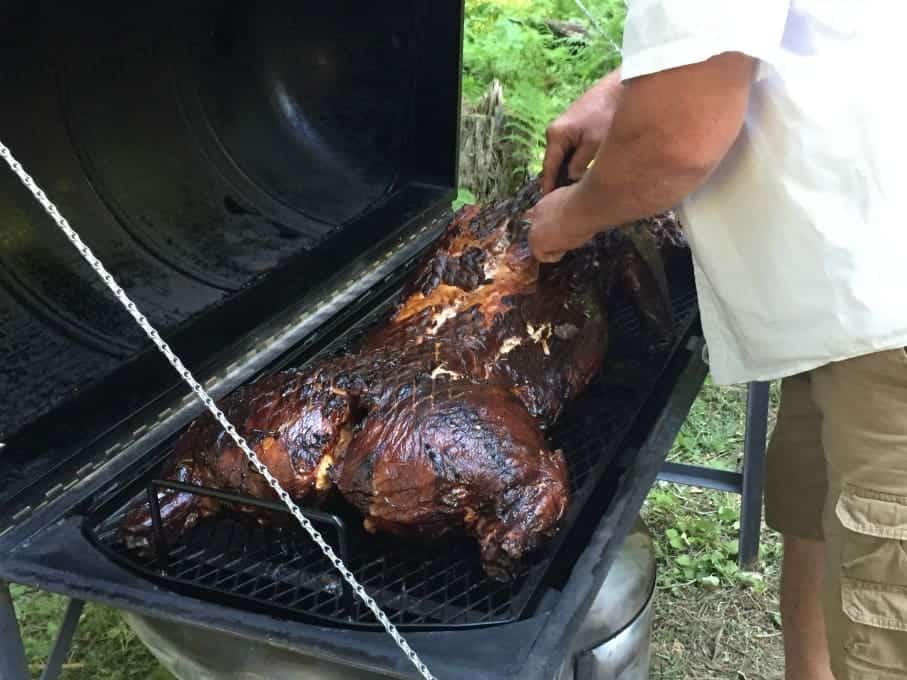 A cooked whole pig on a barbecue grill. 
