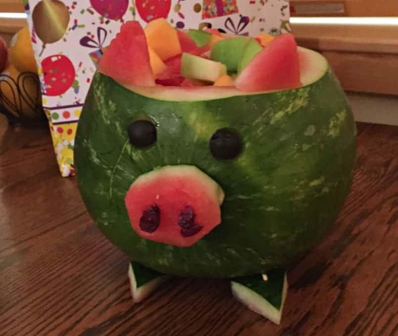 A watermelon decorated like a pig filled with fresh melons.