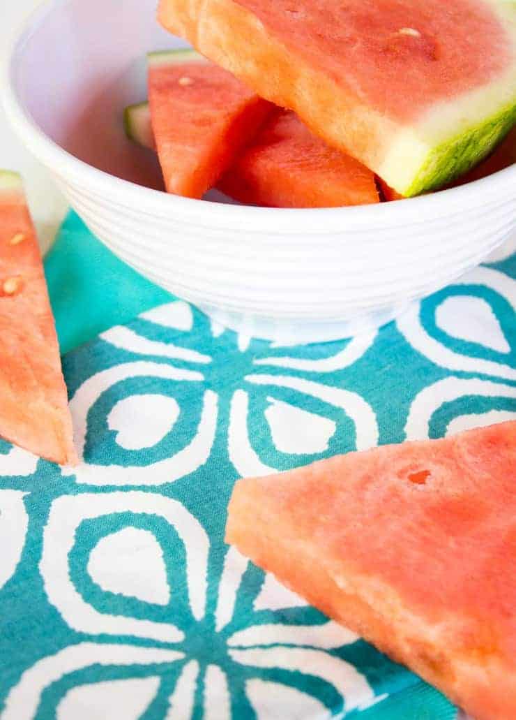Wedges of fresh watermelon on a brightly colored napkin. 