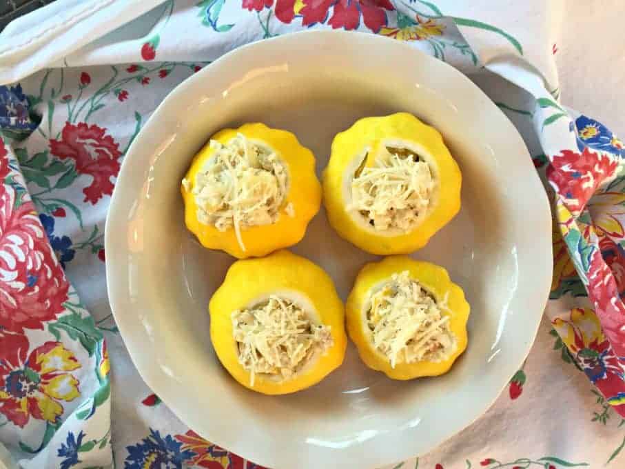 Yellow pattypan squash filled with a stuffing and cheese.