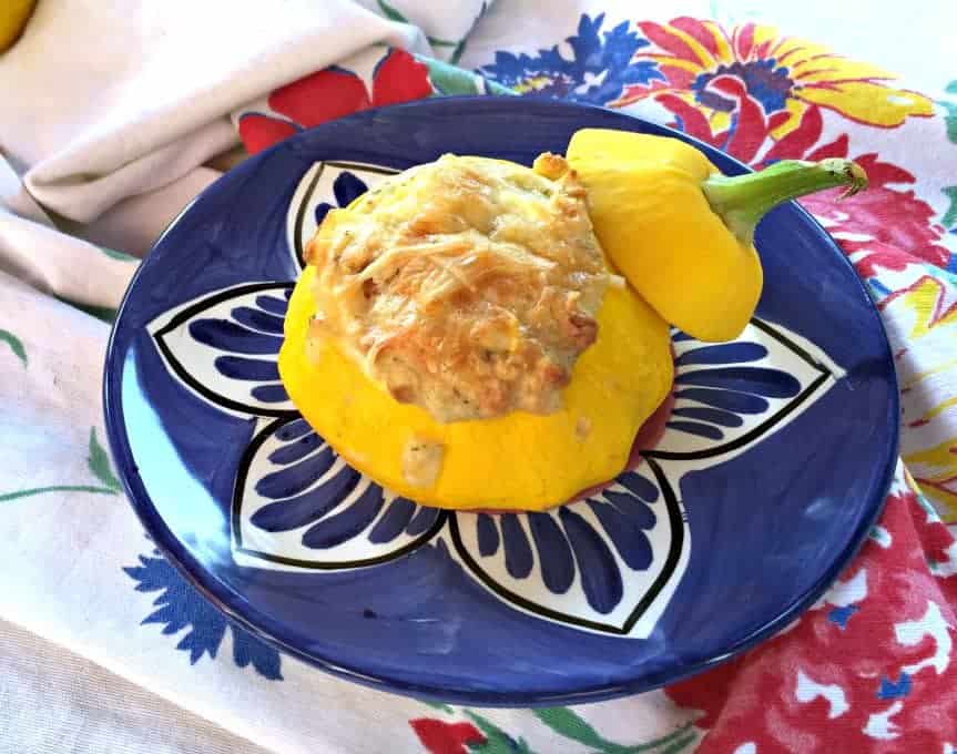 Stuffed Patty Pan squash with the lid of the squash learning on the side.