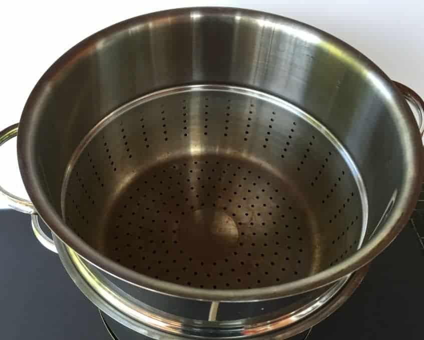 The inside of a steam juicer pot is filled with small holes.