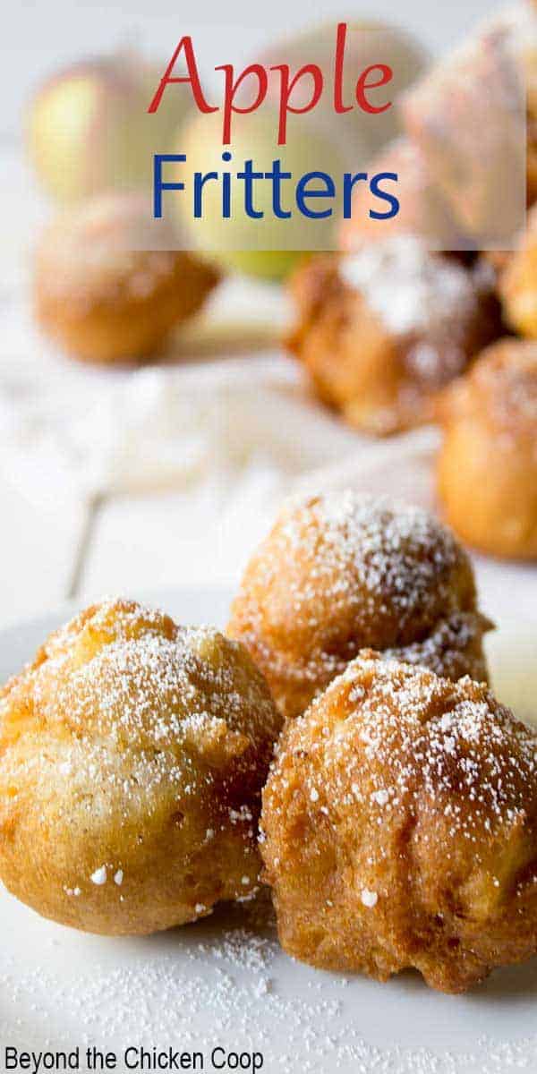 Three round fried apple donuts on a small plate.