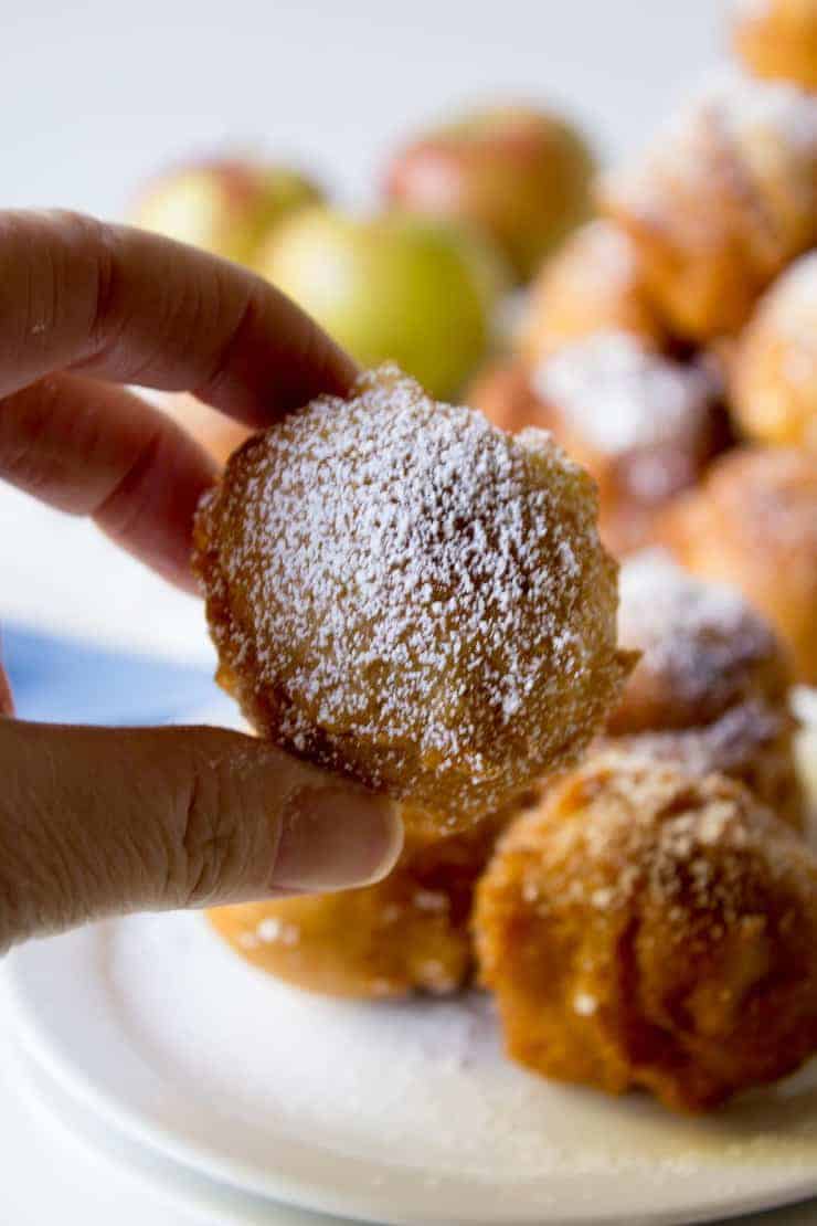 A fritter being held in one hand.