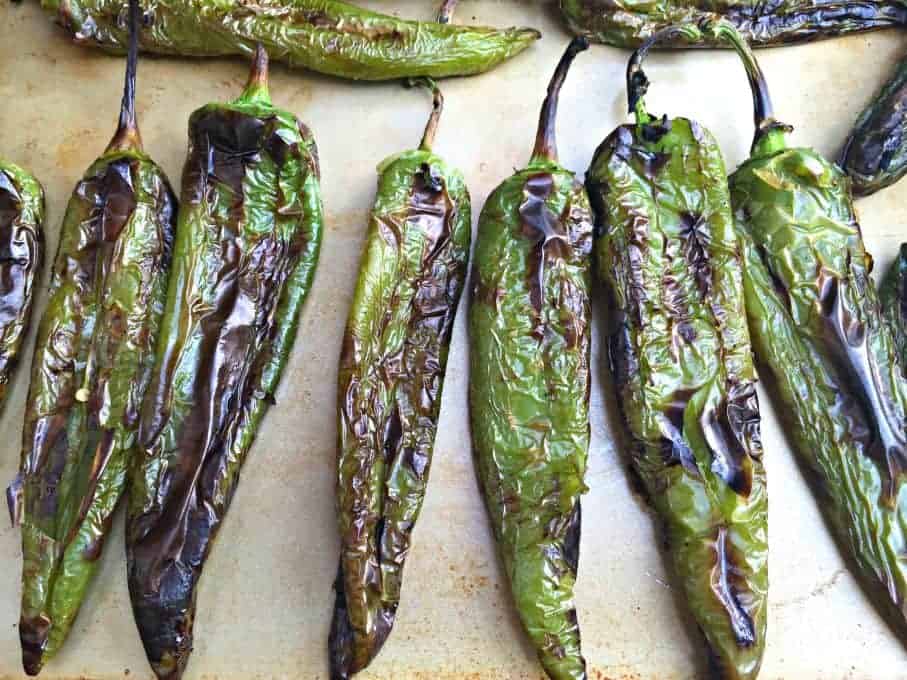 roasted anaheim peppers on a baking sheet.