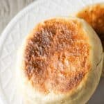 Two golden English Muffins on a plate.