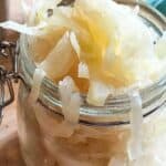 A glass jar filled with fermented cabbage.