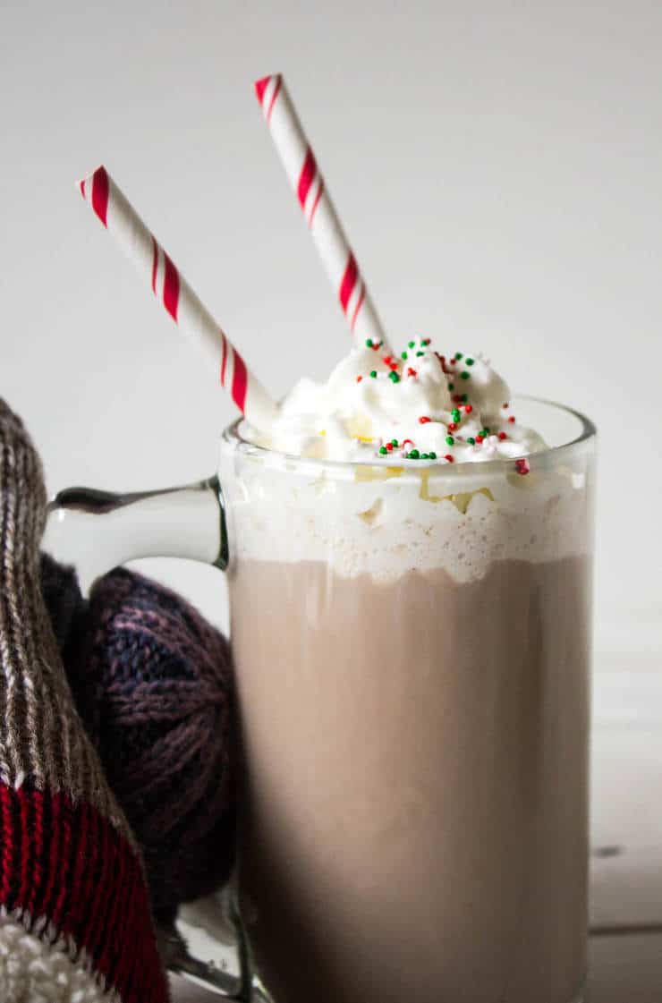 Hot Chocolate in a glass mug with two straws.