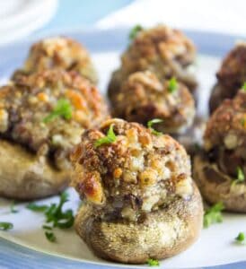 Stuffed mushrooms with golden brown tops on a blue and white plate.