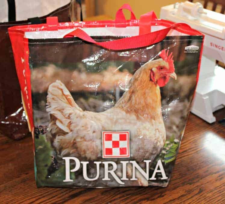 A large tote with a chicken on the front and red handles.