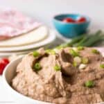 A white bowl filled with refried beans.