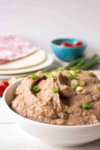 A white bowl filled with refried beans.