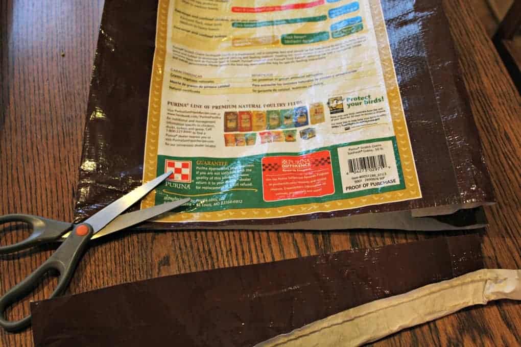 Cutting apart a chicken feed bag. 