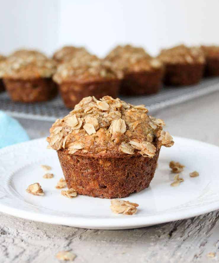 Oatmeal Banana Muffin on a small white plate with crumb topping crumbled on plate.