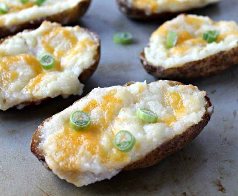 Baked potato halves topped with melted cheese and green onions.