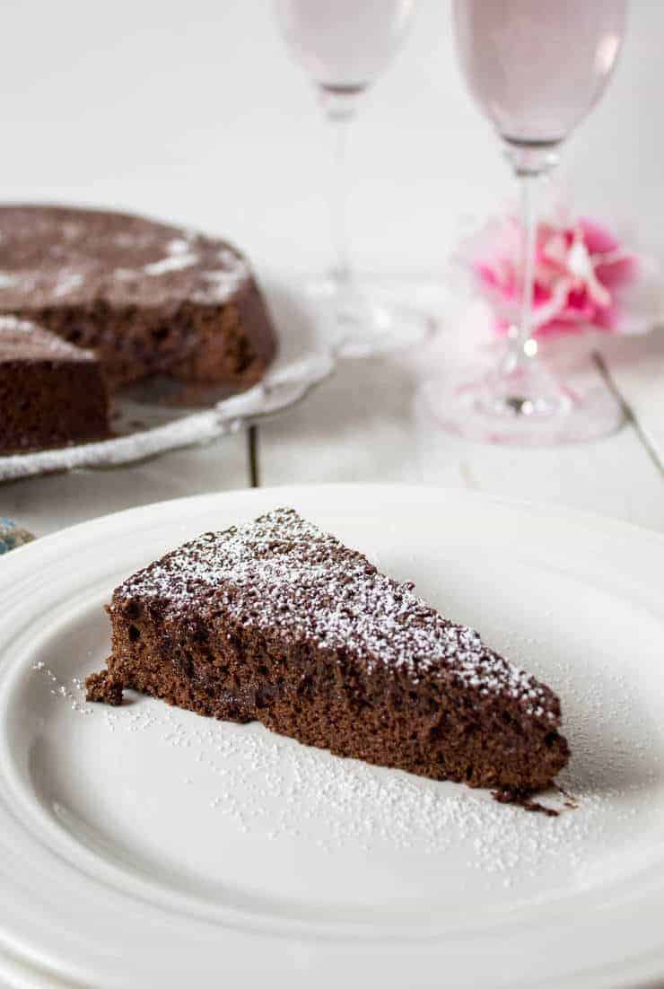 A slice of flourless chocolate cake dusted with powdered sugar.