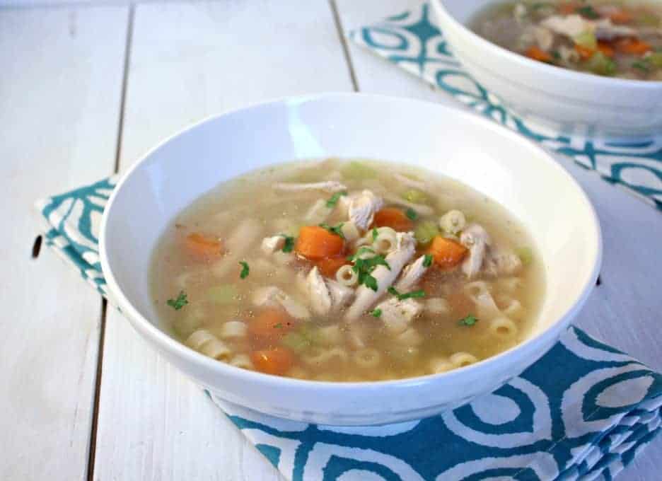 A white bowl filled with chicken noodle soup.