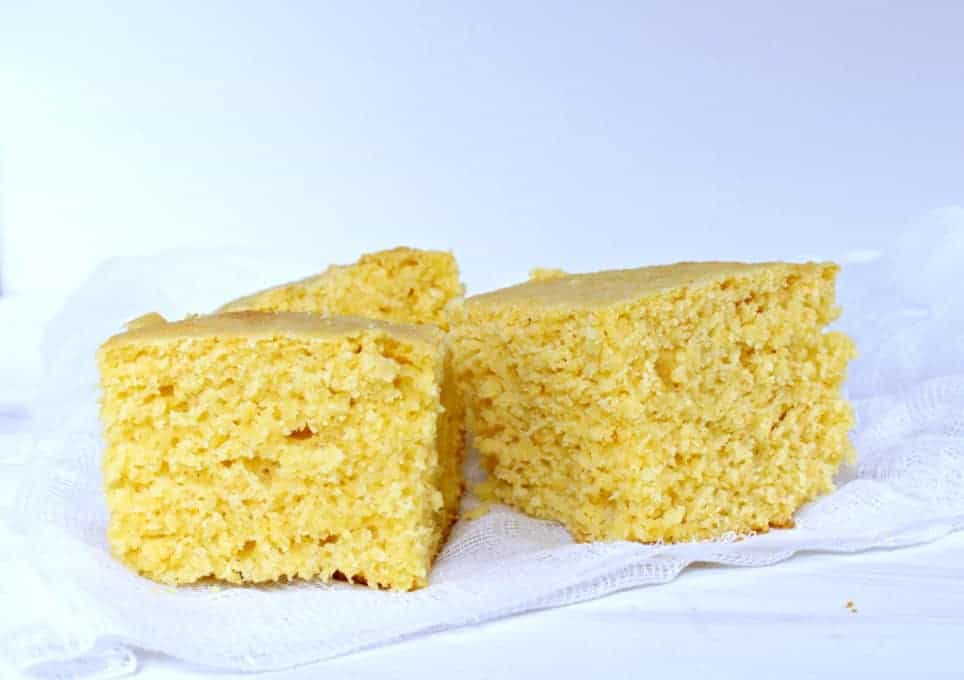 Three pieces of cornbread on a white cloth.