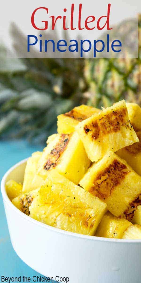 Chunks of grilled pineapple in a small white bowl.