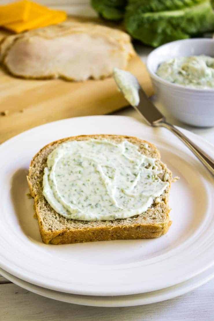 A slice of bread slathered with a fresh herb mayonnaise. 