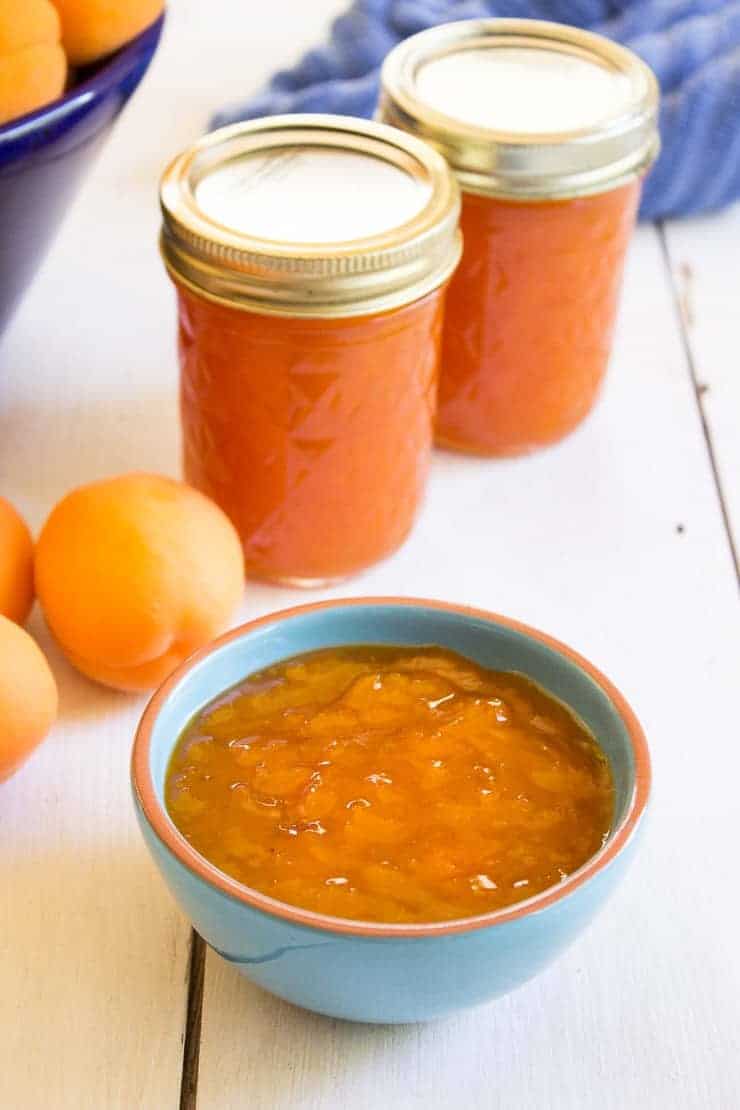 A blue bowl filled with homemade apricot jam.