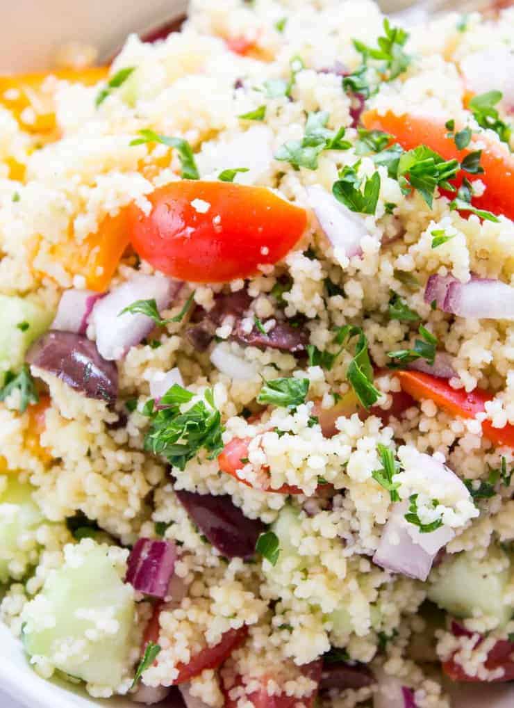 A closeup shot of a salad with fresh tomatoes and chopped parsley.