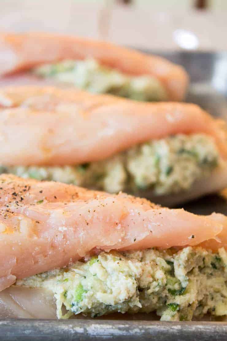 Uncooked stuffed chicken breasts on a baking sheet. 