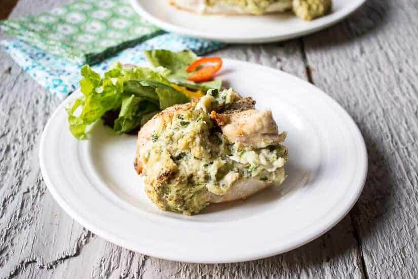 Chicken breast on a plate with a green salad on the plate.