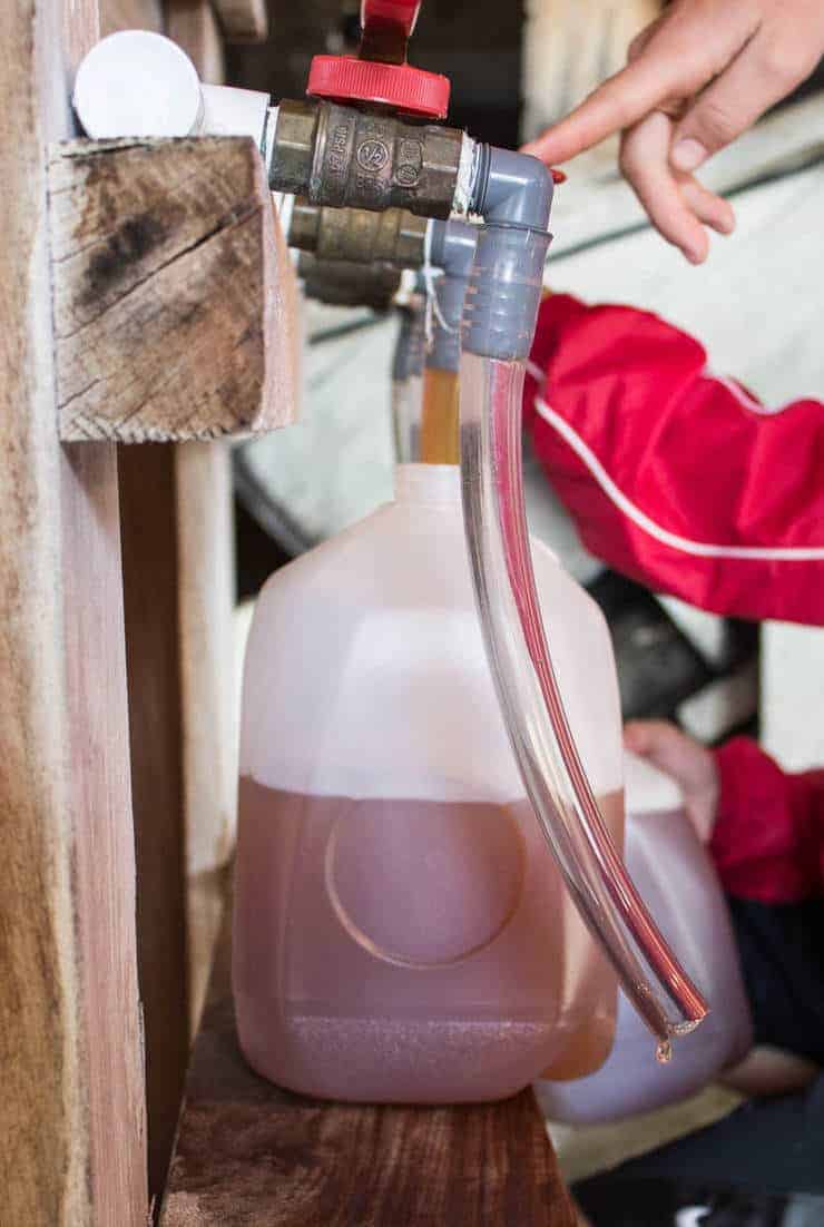 Filling the gallon sized jugs with plastic tubes.