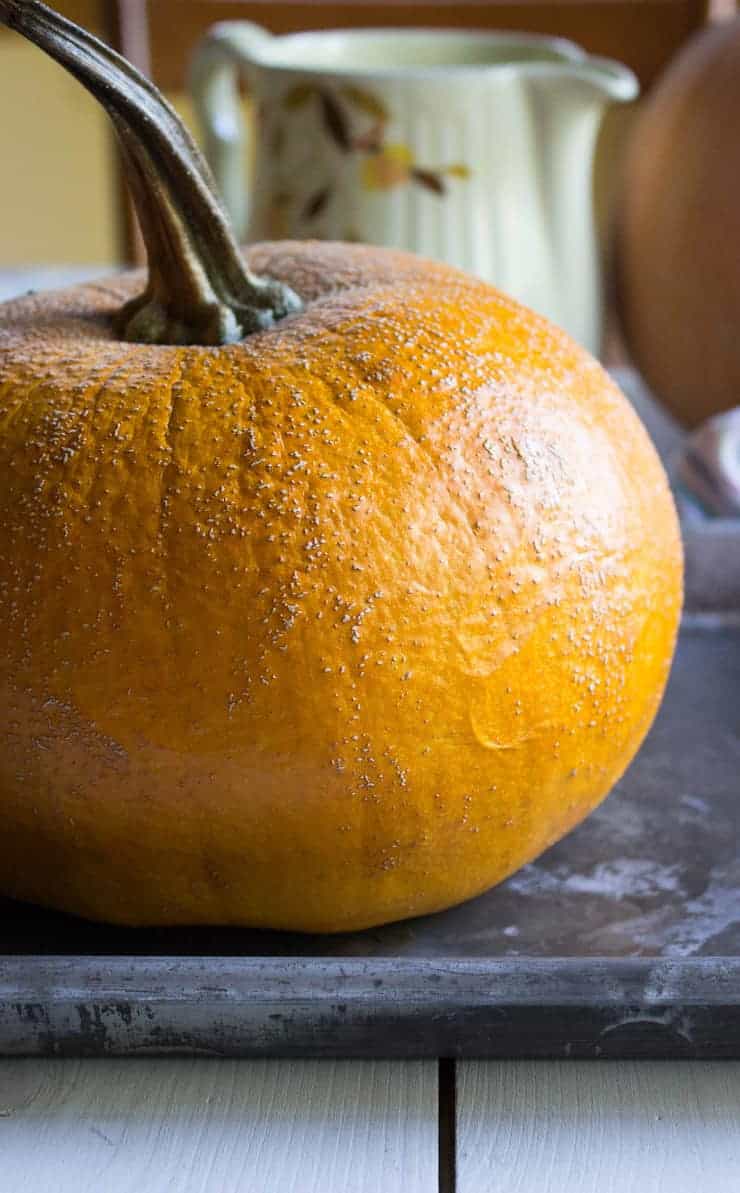 A small pumpkin on a baking sheet.