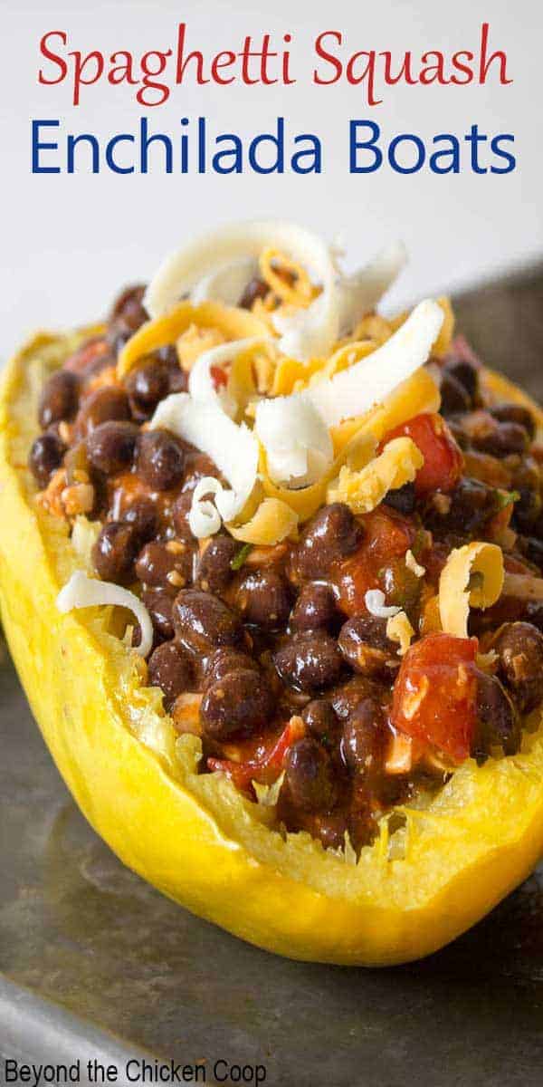 Half of a spaghetti squash filled with black beans and enchilada sauce.