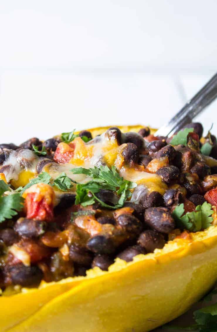 Black beans in a squash shell topped with fresh cilantrol.