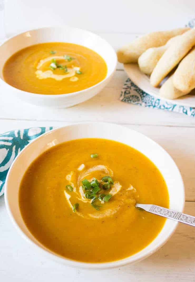 Butternut squash soup served with bread sticks.