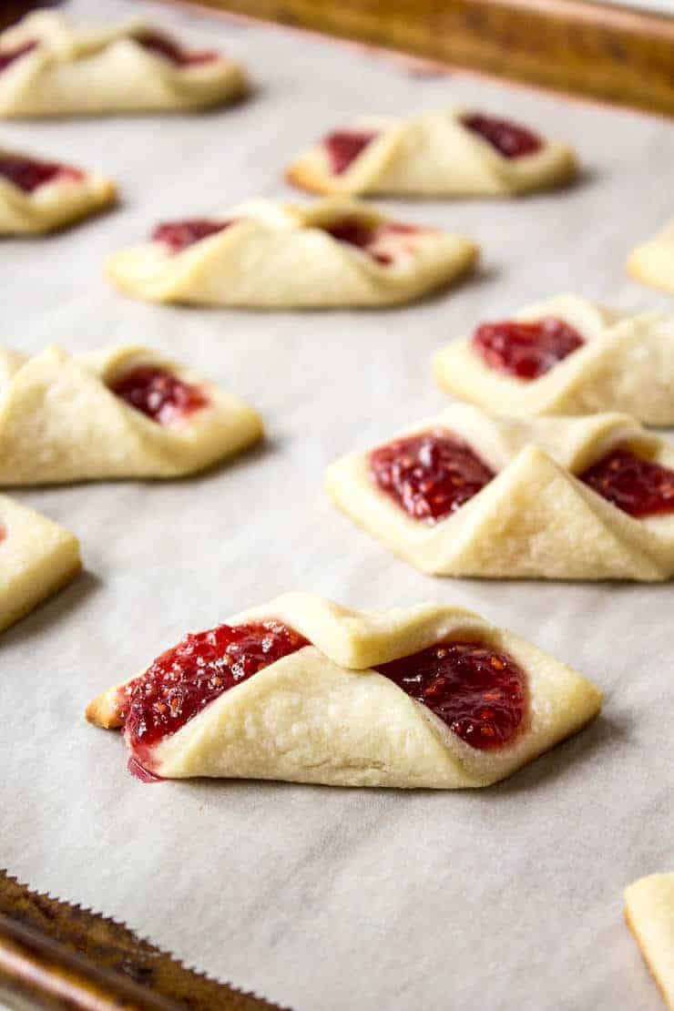 Raspberry Bow Tie Cookies out of the oven on a baking sheet.