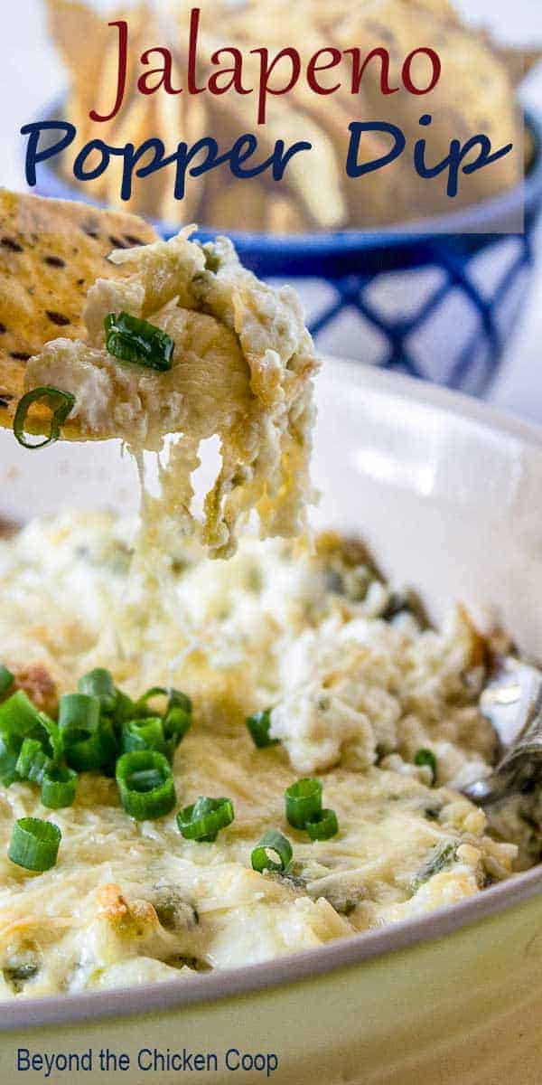 A chip dipping into a cheesy dip.