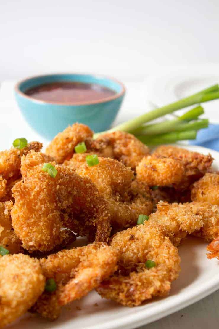 Shrimp on a plate with a garnish of chopped green onions on the top.